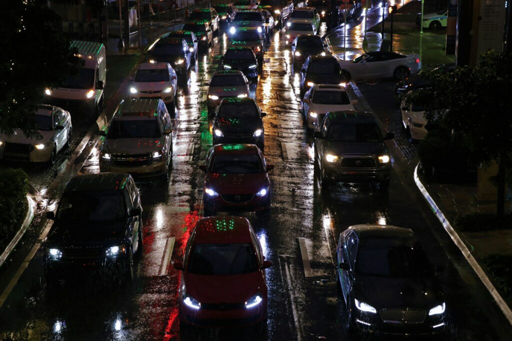 雨の夜、ライトをつけた車がびっしり並ぶ渋滞の道路